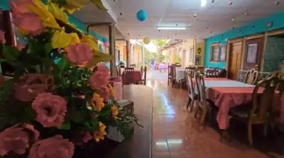 a dining room with a table and flowers on the wall at Hostal y Restaurante Posada Real in La Palma