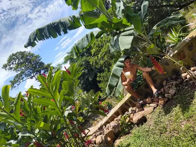 a man in a bikini sitting on the steps of a garden at Casa Hotel Familiar in San Lucas