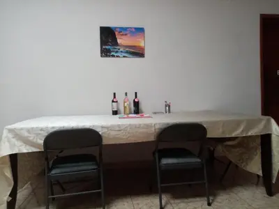 a table with two chairs and bottles of wine at Casa Hotel Familiar in San Lucas
