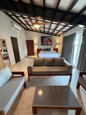 a living room with a couch and a bed at HOTEL TESORO BEACH in San Luis La Herradura