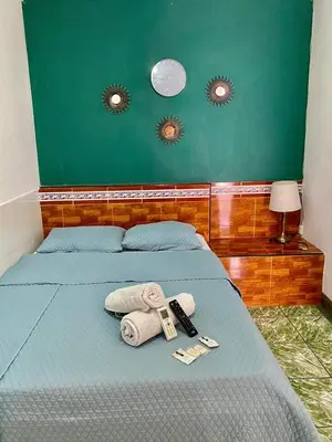 a bedroom with a bed with towels and two mirrors at hotel marsella in Sonsonate