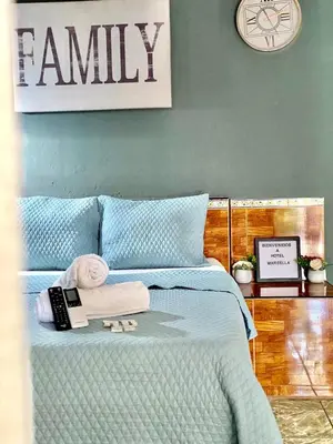 a bedroom with a bed with towels and a clock at hotel marsella in Sonsonate