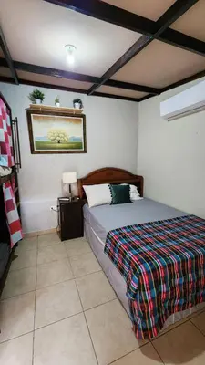 a bedroom with a bed with a colorful blanket on it at Bed and breakfast Tía Mema in Santa Ana