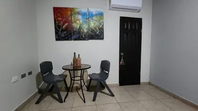 a dining room with a table and chairs and a painting at Bed and breakfast Tía Mema in Santa Ana