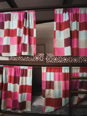 a bunk bed with pink and white curtains on it at Bed and breakfast Tía Mema in Santa Ana